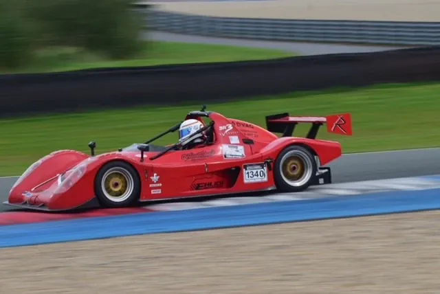 Roter Radical SR3 mit der Startnummer 1340 in Seitenansicht auf der Rennstrecke, der Fahrer im weißen Helm ist im offenen Cockpit zu sehen