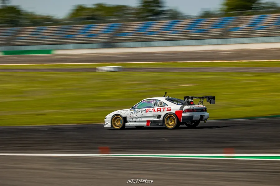 Weißer Toyota MR2 mit der Startnummer 70 in voller Fahrt auf der Rennstrecke, der Hintergrund ist von der Mitzieher-Aufnahme verwischt